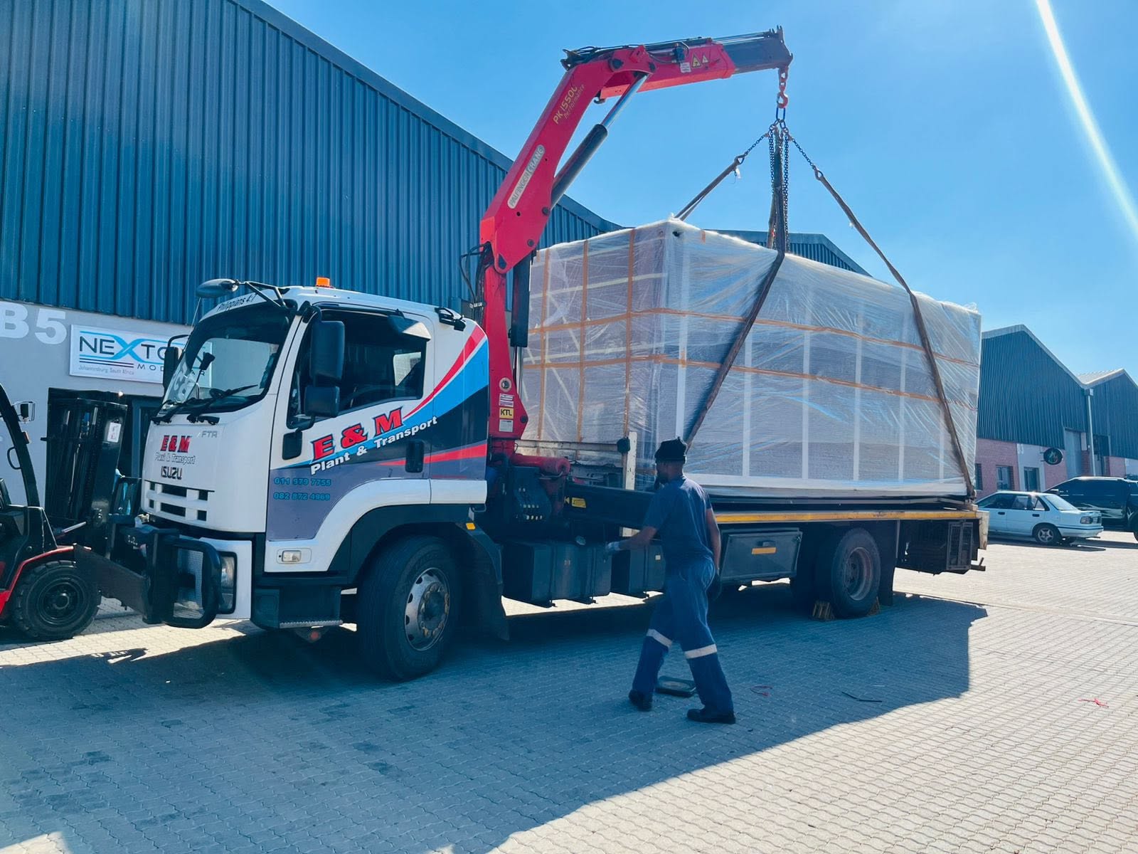 Crane truck lifting a wrapped industrial load